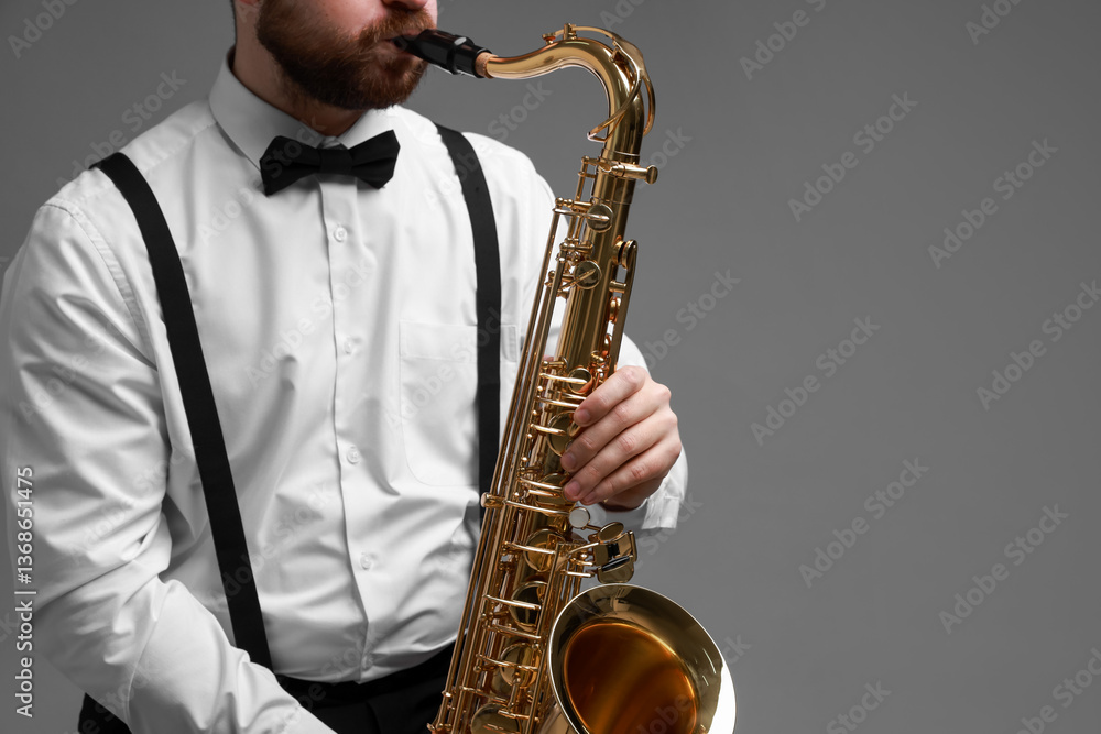 Fototapeta premium Professional musician playing saxophone on grey background, closeup. Space for text