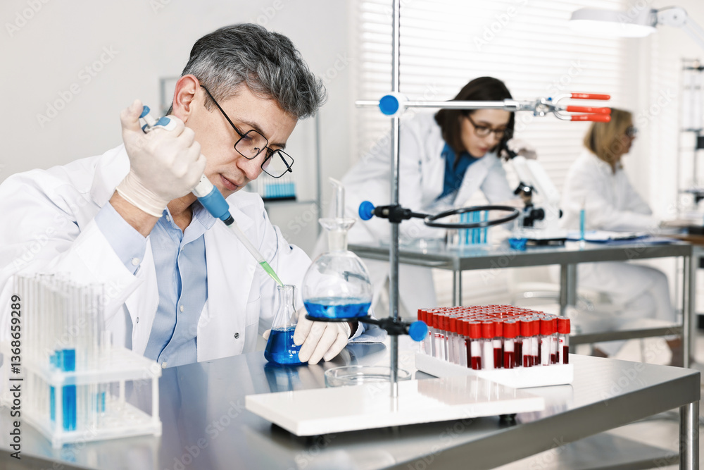 Scientist with micropipette and flask working in laboratory Scientist with micropipette and flask working in laboratory