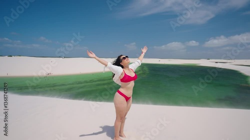 Portrait of woman on desert dunes between rain water lagoons. Brazil Northeast.
