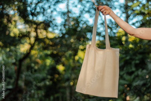 hand holding raw cotton ecobag without print nature background