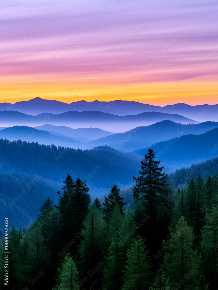 Obraz premium Serene sunset over layered, hazy blue mountains and evergreen forest