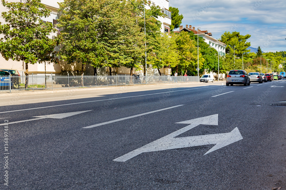 Obraz premium Urban street scene with traffic and road markings in Podgorica, Montenegro on a sunny day
