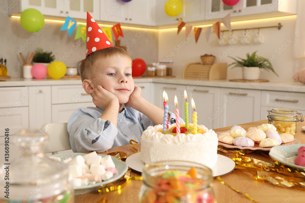 Fototapeta premium Cute little boy with birthday cake at table indoors. Surprise party