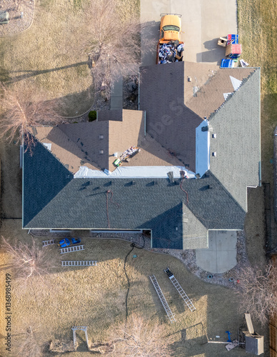 Obraz na płótnie aerial view above a re-roofing overlay project at a residential house where new shingles are placed on top of existing tiles