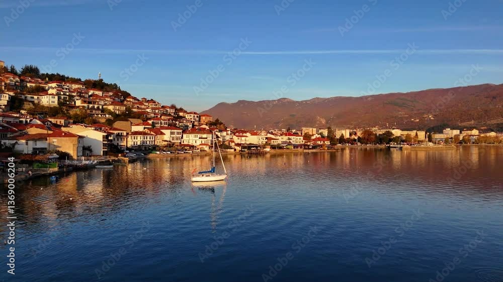 Flying over Lake Ohrid towards the Old Town of Ohrid with a sailboat in the water Flying over Lake Ohrid towards the Old Town of Ohrid with a sailboat in the water