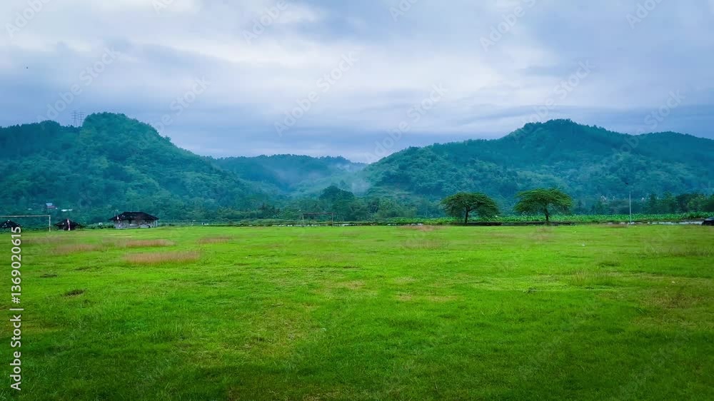 Green Field with Mountain View Under Cloudy Sky Green Field with Mountain View Under Cloudy Sky