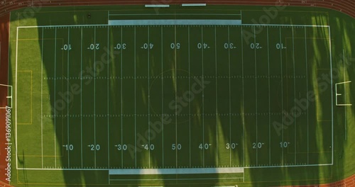 Aerial top down birds eye view of a football field at sunrise.