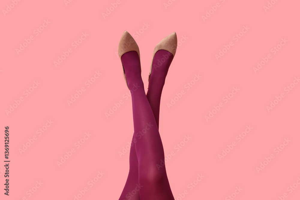 Fototapeta premium Legs of young woman in tights and heeled shoes on pink background