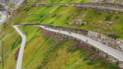 Drone shot of cyclists driving over the hairpin road of the Stelvio Pass, Italy