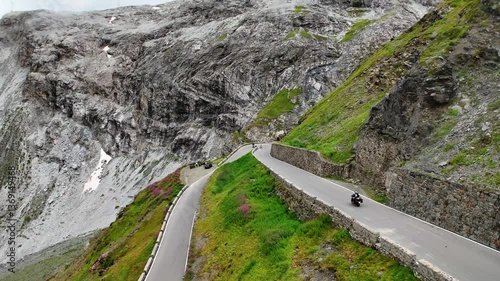 Drone shot of a motorcycle driving over the Prato allo Stelvio Pass, Italy