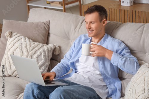 Smiling young man with cup ...