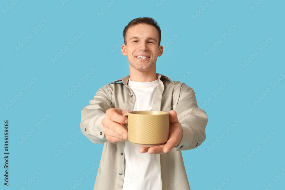 Young man with cup of coffee on blue background Young man with cup of coffee on blue background