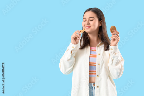 Young woman eating cookies ...