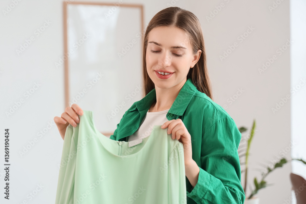 Happy young fashion blogger unpacking new stylish dress at home Happy young fashion blogger unpacking new stylish dress at home