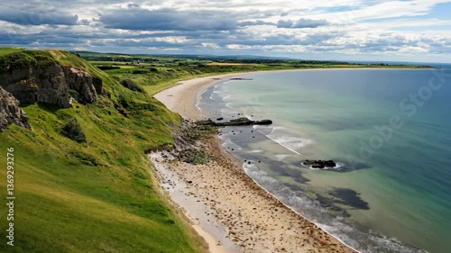Coastal landscape with sandy beach and rocky shore under a cloudy sky in Northern Ireland