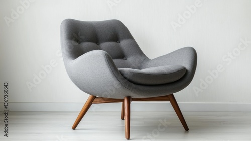 A mid-century modern lounge chair with wooden legs, in a minimalist studio.