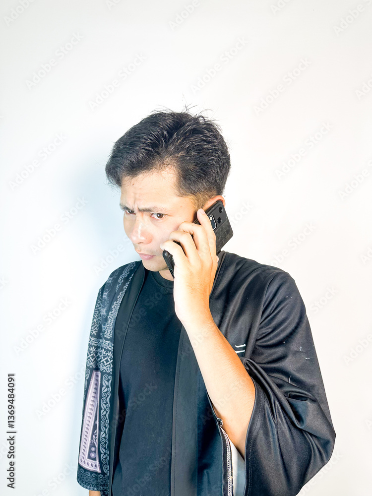 Pensive Man Talking on Mobile Phone in Traditional Robe Pensive Man Talking on Mobile Phone in Traditional Robe
