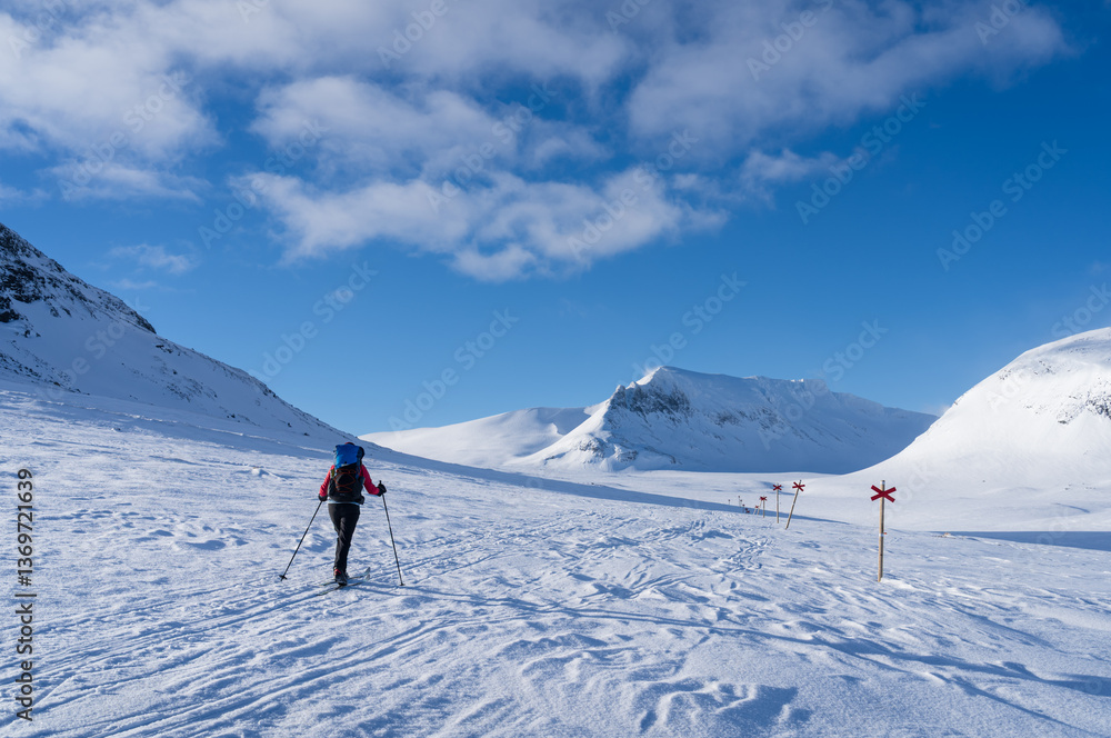 Woman cross-country skiing toward mountain Templet, in the Sylarna mountain range. Sweden.
