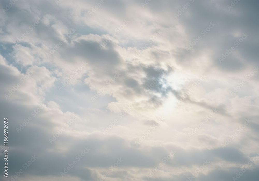 Obraz premium A sky filled with soft clouds where the sun's gentle glow creates a serene vista.