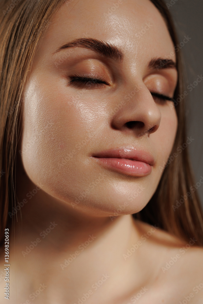 Obraz premium Young woman with glowing skin and closed eyes enjoying relaxation indoors during a calm moment