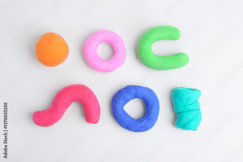 Obraz premium Different colorful play dough on white background, flat lay