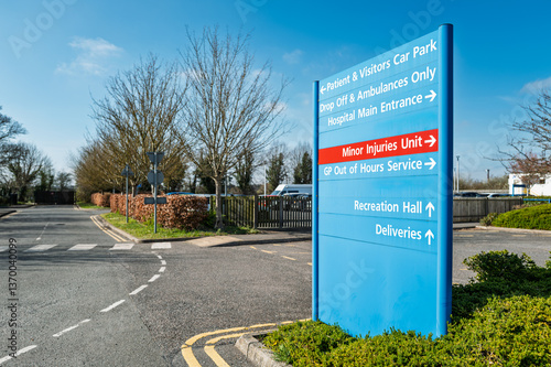 Obraz na płótnie Large blue patient and visitor information and parking sign seen within the campus of a typical NHS hospital in Britain. The red sign is for the Minor Injury department. w salonie
