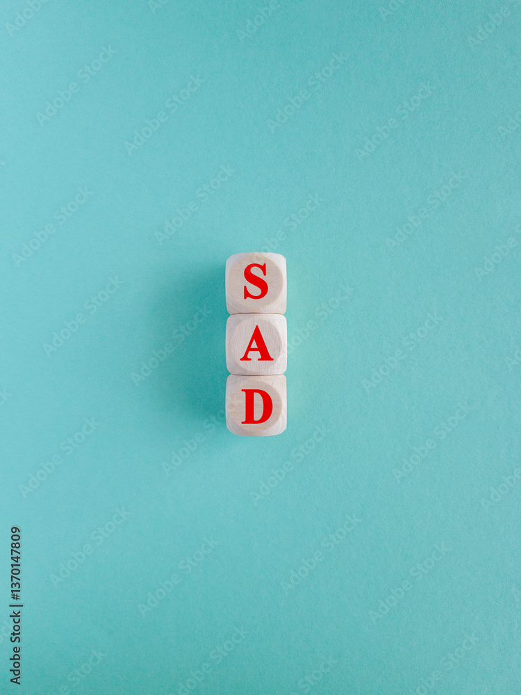 Sad symbol. Wooden cubes with words Sad. Beautiful blue background. Business and Sad concept.
