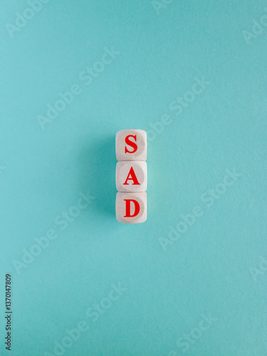 Obraz na płótnie Sad symbol. Wooden cubes with words Sad. Beautiful blue background. Business and Sad concept. w salonie