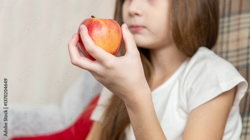 Happy little girl eating apple sitting on the sofa living-room Happy little girl eating apple sitting on the sofa living-room