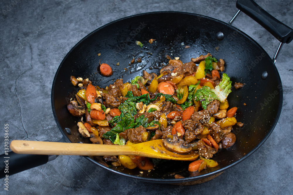 Stir fry made with seitan and various veggies, mushrooms in black cast iron wok Stir fry made with seitan and various veggies, mushrooms in black cast iron wok