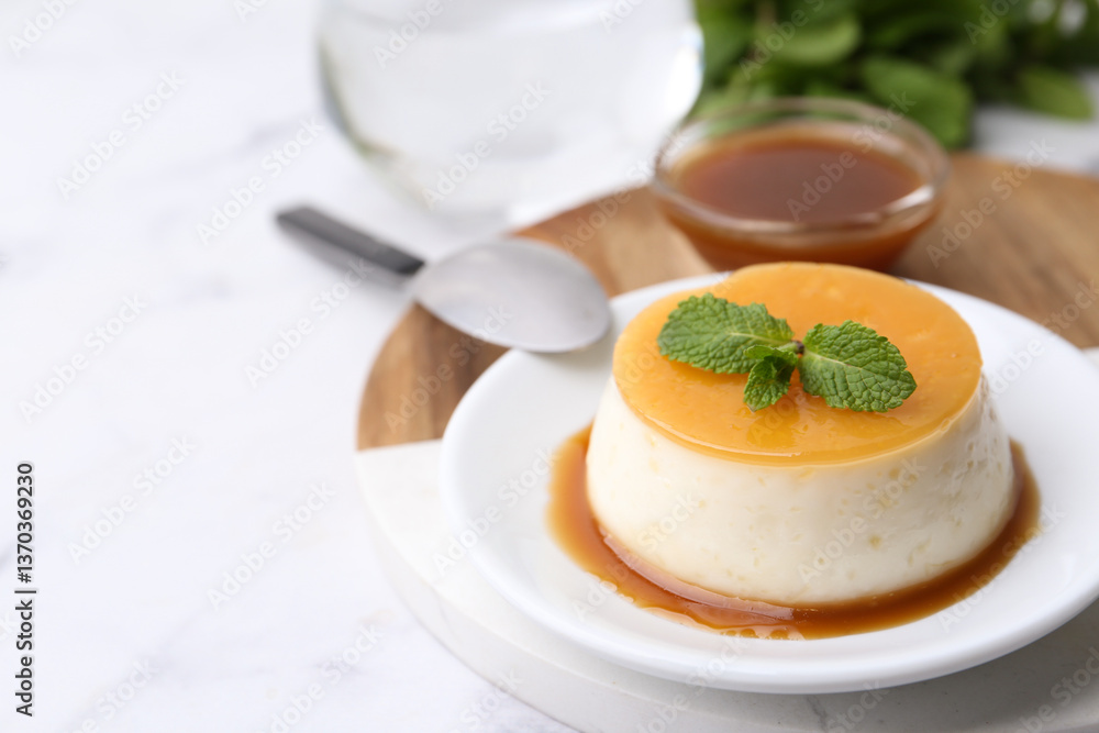 Tasty pudding with caramel sauce served on white marble table, closeup. Space for text Tasty pudding with caramel sauce served on white marble table, closeup. Space for text