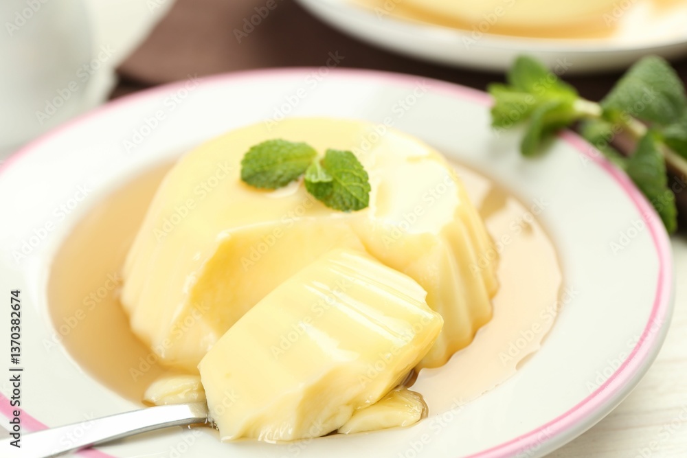 Delicious pudding with caramel sauce and mint served on white table, closeup Delicious pudding with caramel sauce and mint served on white table, closeup
