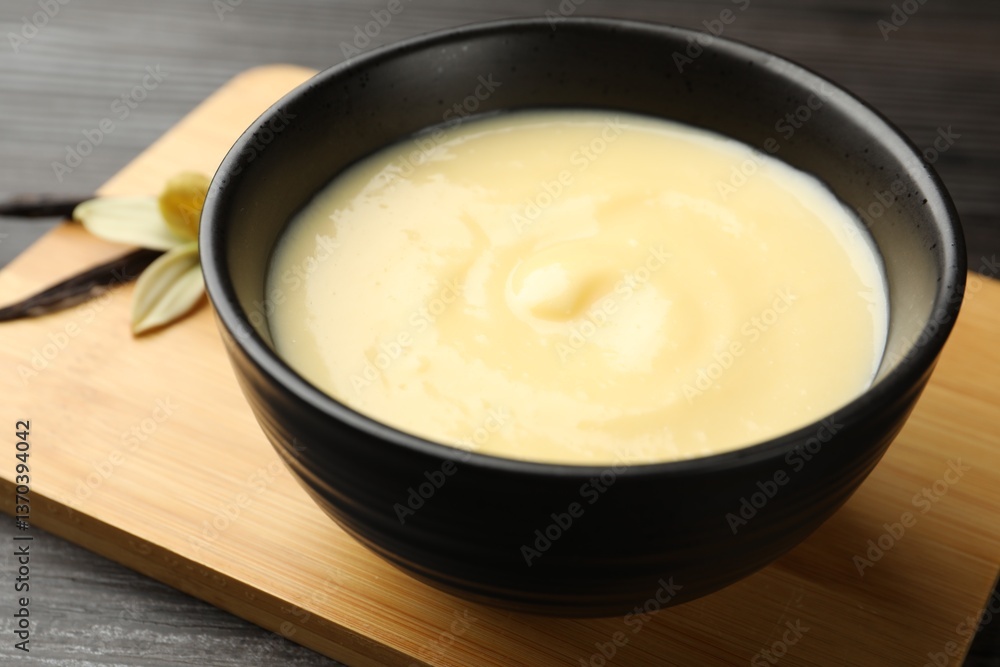 Tasty vanilla pudding in bowl on wooden table, closeup Tasty vanilla pudding in bowl on wooden table, closeup