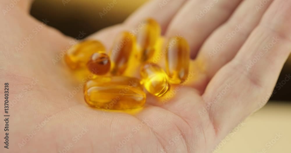 Golden vitamin capsules on palm. Dietary supplements and nutrition concept. Health care and wellness products. Macro photography of pills for immunity boost. Medicine and pharmaceutical drugs Golden vitamin capsules on palm. Dietary supplements and nutrition concept. Health care and wellness products. Macro photography of pills for immunity boost. Medicine and pharmaceutical drugs