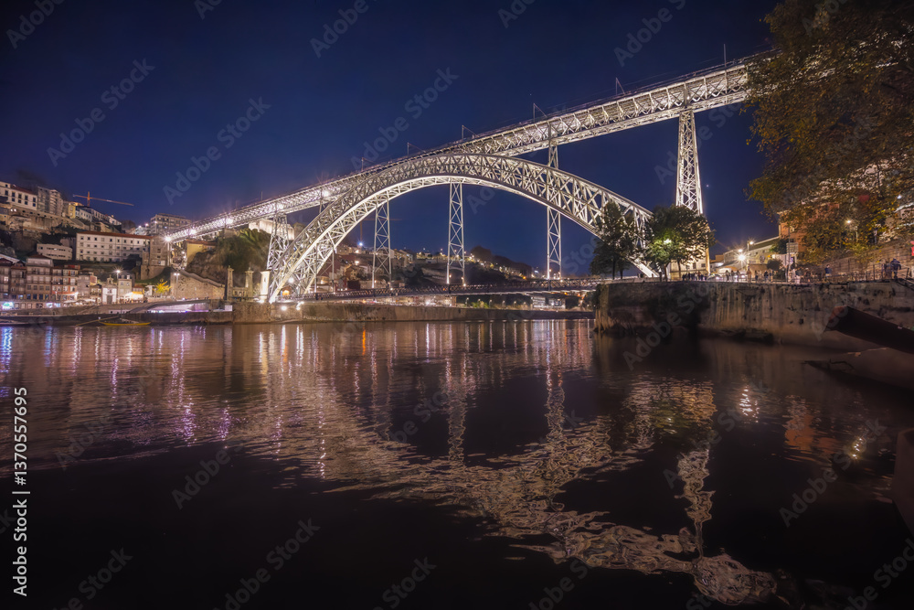 Porto, Portugal - A mesmerizing view of the Douro River at night with the Ponte Dom Luis I bridge brilliantly illuminated against the dark skyline. Porto, Portugal - A mesmerizing view of the Douro River at night with the Ponte Dom Luis I bridge brilliantly illuminated against the dark skyline.