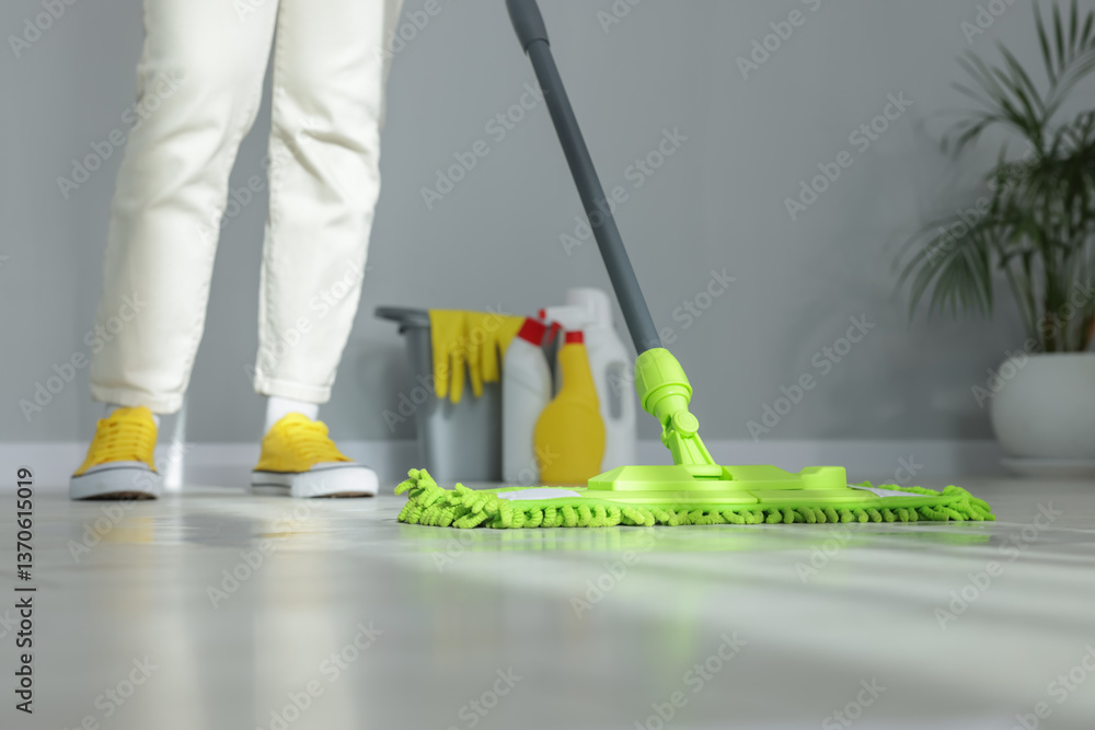 Fototapeta premium Woman cleaning floor with microfiber mop indoors, closeup