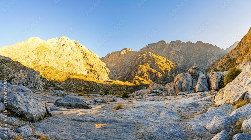 Obraz premium Sunrise Over Majestic Mountain Range, Golden Light Casts Long Shadows on Rugged Terrain, Captured with Wide-Angle Lens.
