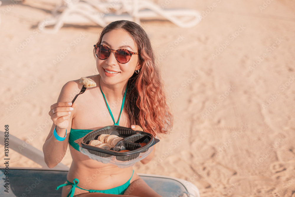 Tourist enjoying a quick and tasty meal of dumplings directly on the beach during her vacation