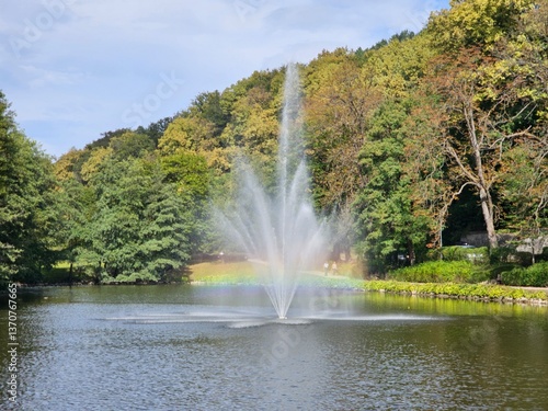 Rainbow in the fountain among the pond in the park
