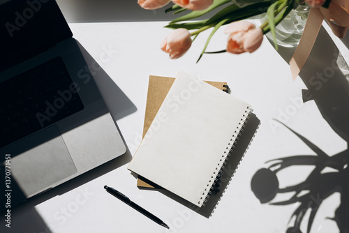 Flat lay with flowers and paper note with space for text. Woman workspace.