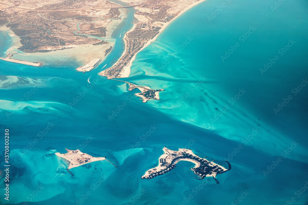 Aerial view of artificial islands under construction near the coast, showing luxury resorts and turquoise blue water
