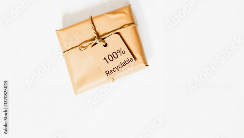 A kraft paper package tied with jute string, with a minimal branded tag reading '100% Recyclable'. Shot on a plain white surface with soft shadows and no filters