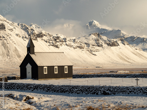 Búðakirkja black church in Iceland’s Snæfellsnes Peninsula, surrounded by snow and mountains. Iconic Nordic architecture in a dramatic and peaceful winter setting