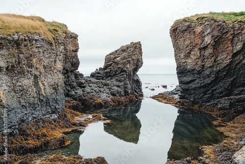 Serene coastal landscape with rocky formations and calm waters reflecting the sky