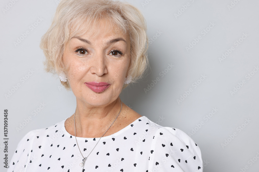 Portrait of grandmother on light grey background. Space for text Portrait of grandmother on light grey background. Space for text