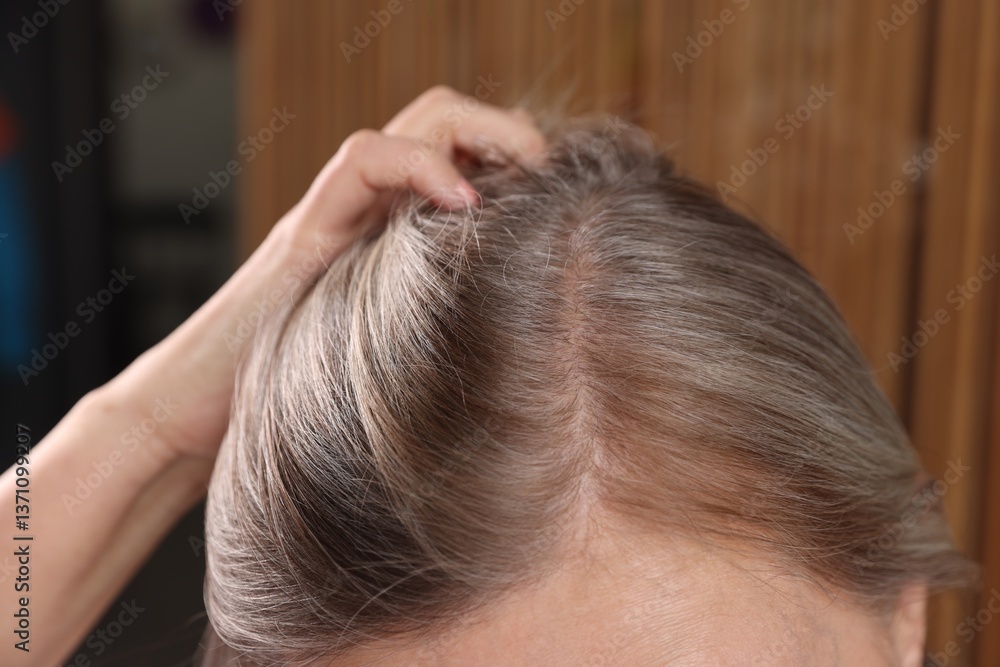 Naklejka premium Senior woman with healthy hair roots on blurred background, closeup