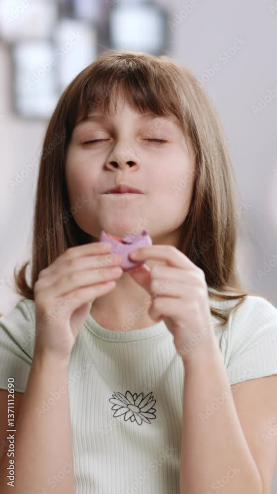 Vertical Format Video of Attractive brunette school girl on a home background, licks her lips, looks at camera eating one violet macaron, closes her eyes with pleasure Vertical Format Video of Attractive brunette school girl on a home background, licks her lips, looks at camera eating one violet macaron, closes her eyes with pleasure