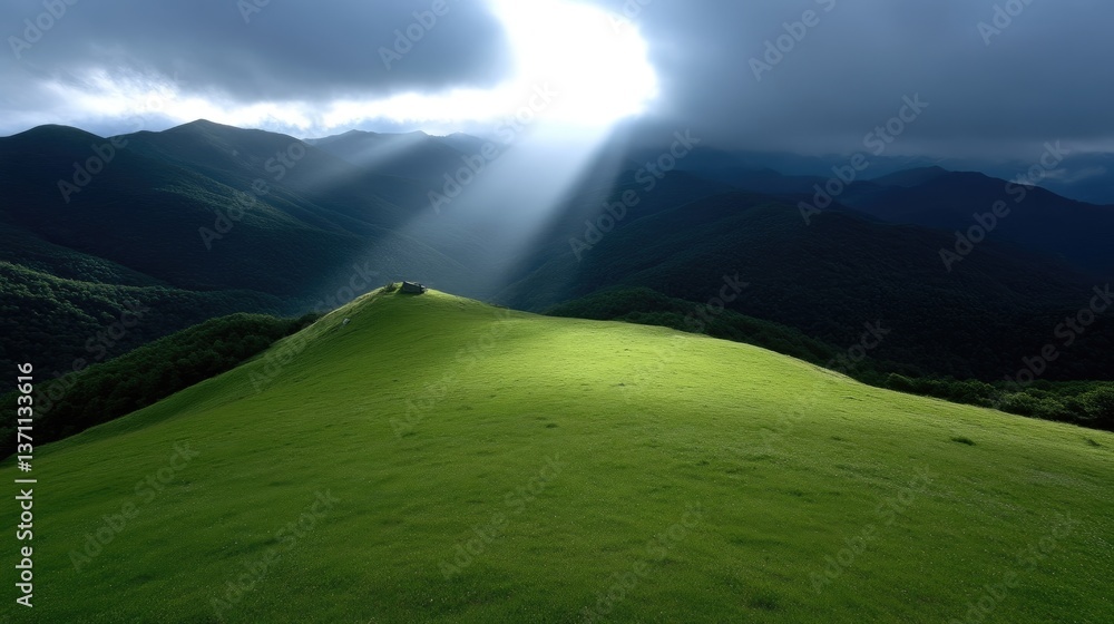 Fototapeta premium Sunlight piercing through clouds over a verdant mountaintop