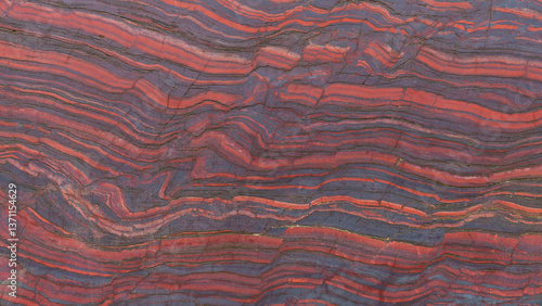 Close up cut red stone with natural patterns and texture. Banded iron ore. Mineral structure, geological layers, natural background for design.