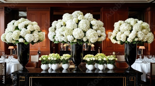 Elegant white hydrangea floral arrangements in black vases displayed on a mantle